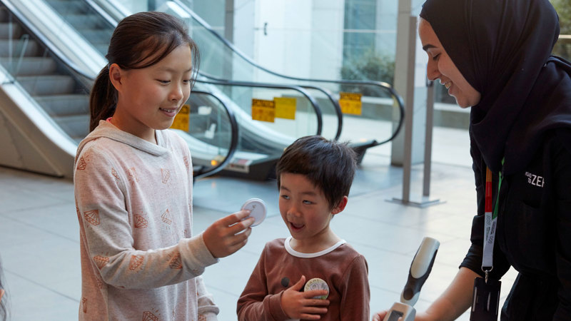 Children take part in a badge making activity. 