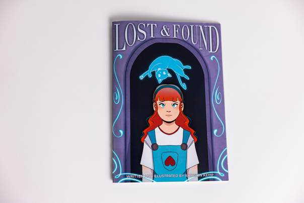 Book cover featuring an illustrated girl with long red hair, wearing blue and white. A blue cat floats above her head.