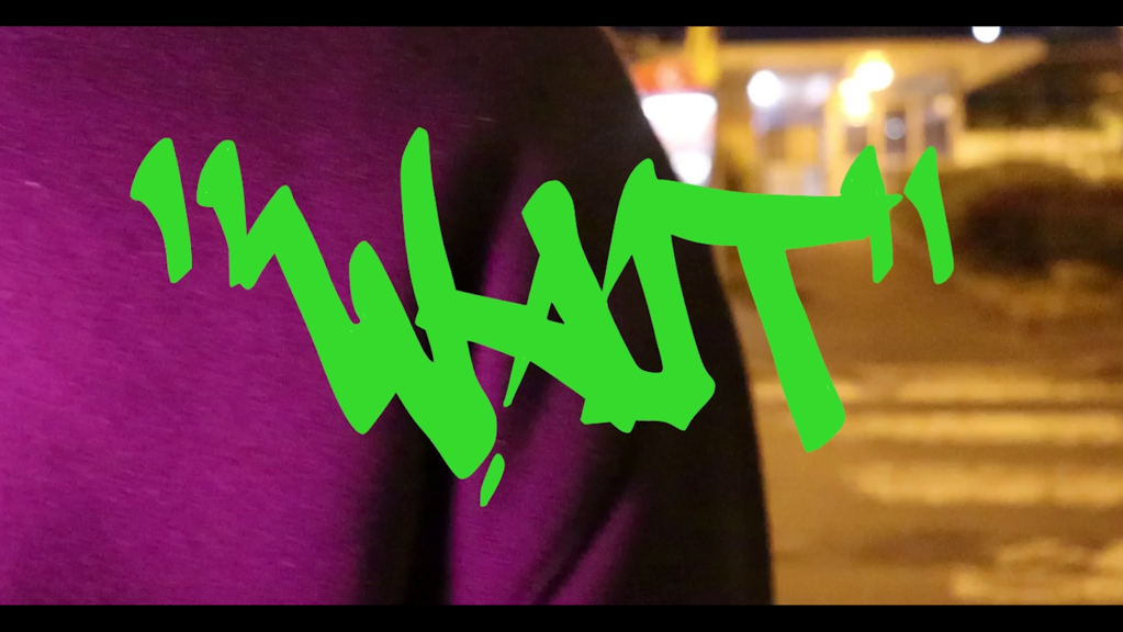 The word 'WAIT' in lime-green graffiti-style writing, overlaid on a close-up of purple fabric, with a blurred, nighttime urban background.