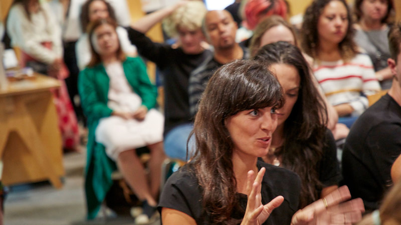 Audience member participates in a discussion at a panel talk event.  