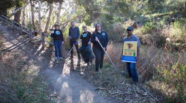 A group of volunteers clean up along a river