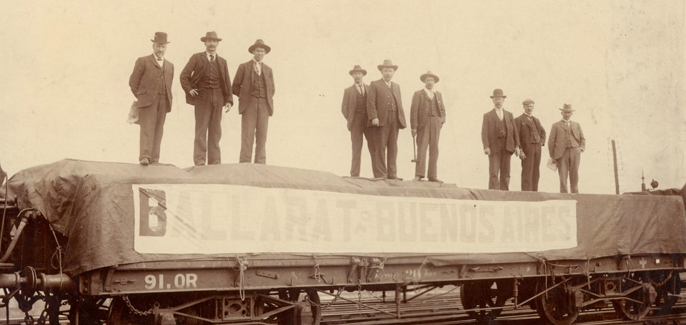 Men standing on top of a loaded rail carriage