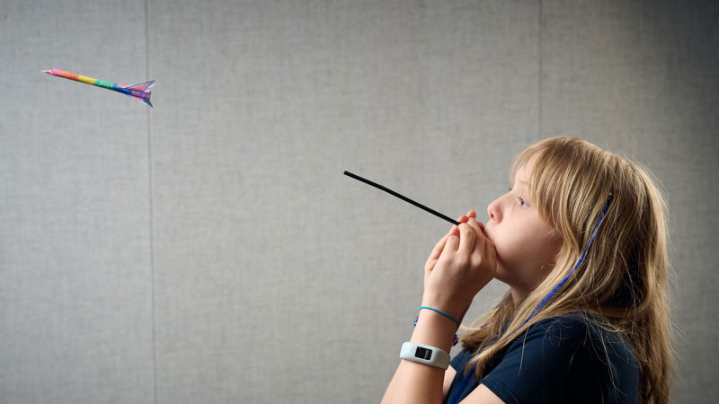 A young adult fires a blow-dart  during a Science Studio workshop at Scienceworks.
