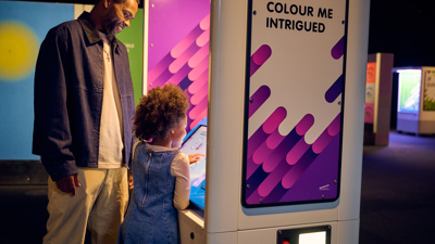 A child and guardian interacting with a digital display in Colour exhibition at Scienceworks