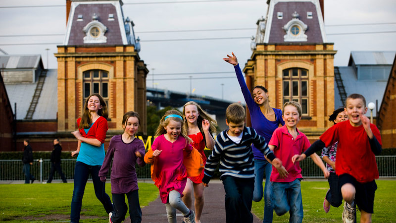 Children running in front of the Spotswood Pumping Station.