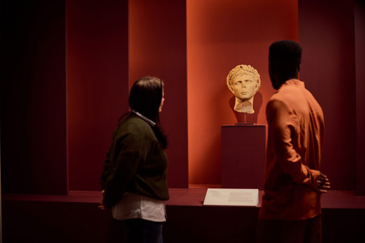 Visitors viewing a roman bust ROME: Empire, Power, People exhibition in Melbourne Museum.