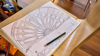 A closeup of a sketch book where someone has drawn the iconic half-circle window of the Royal Exhibition Building.