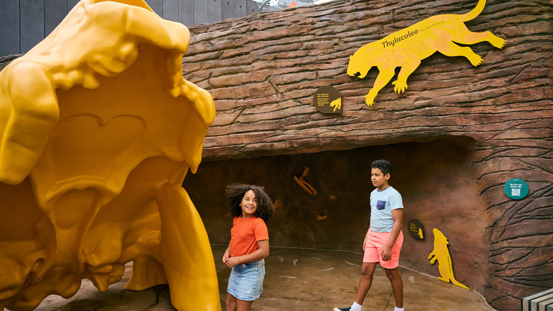Boy and a girl exploring a giant yellow skull in the Gandel Gondwana Garden