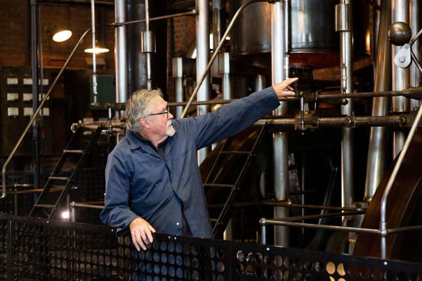 Engine Driver standing in front of a large steam engine.