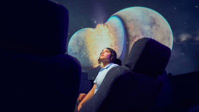 A secondary school student observes projection on the dome of the Melbourne Planetarium.