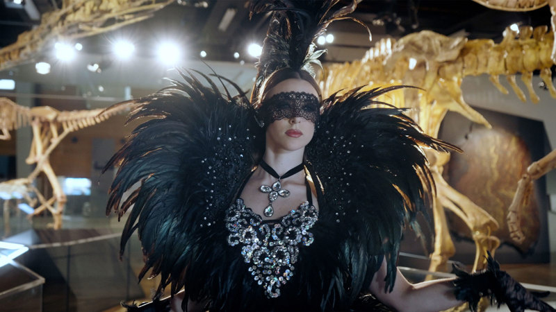 A women wearing a lacey and feathered black fancy outfit.