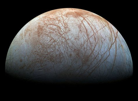 Detailed image of Europa's icy surface, displaying intricate reddish-brown lineae and fractures spread across the moon's bright ice-covered exterior against the darkness of space.