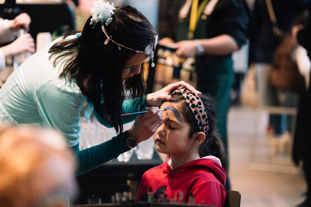 A woman painting a child's face during NAIDOC Week at Melbourne Museum.