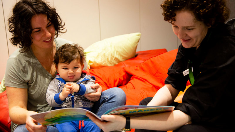A Mum and child enjoy a book together.