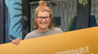 A woman stands with a placard