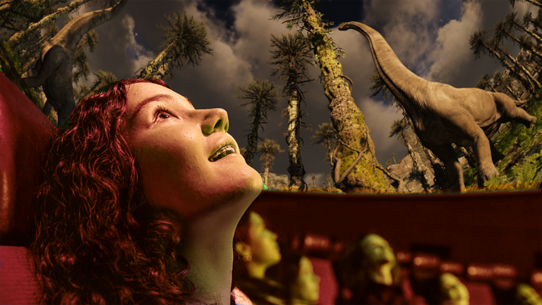 The face of a teenager in profile siting in the Melbourne Planetarium looking up in wonder at a film featuring dinosaurs above them.